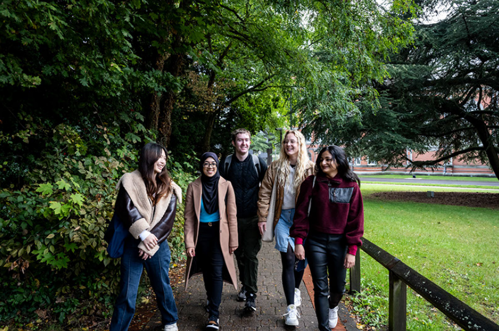 Group of students smiling and walking towards camera